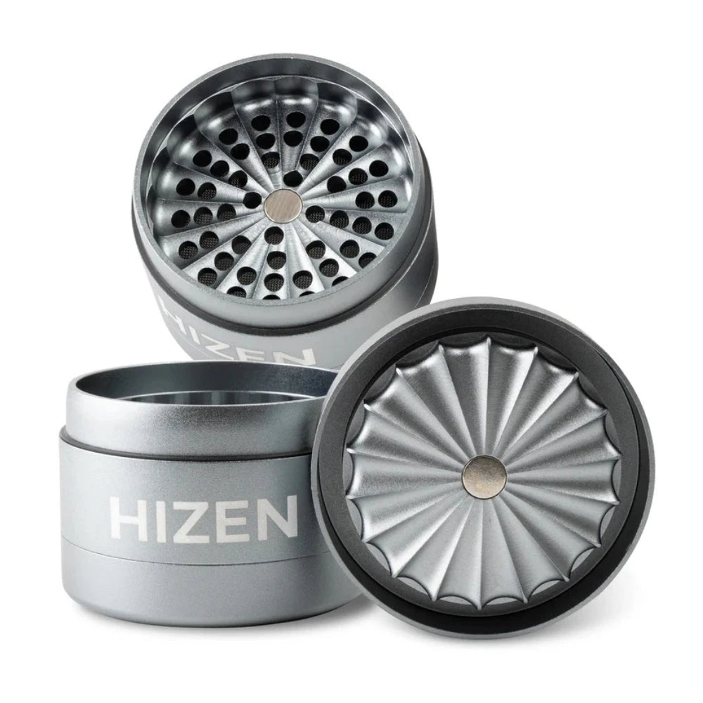 Hizen Grinder zahnlos 63mm in Grau – geöffneter 4-teiliger Aluminium-Grinder mit sternförmigem Mahlwerk, Lochsieb und Magnetverschluss, drei Teile auseinander dargestellt